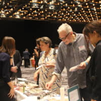 Cooking workshop coordinator Pamela Woods (center) samples some of the products at the Premium Japanese Food Showcase in Sydney on Monday. | KYODO