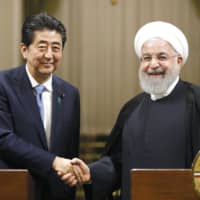 Prime Minister Shinzo Abe and Iranian President Hassan Rouhani shake hands after a joint news conference in Tehran on June 12. | KYODO