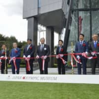 Seiko Hashimoto (center, right), the minister in charge of the 2020 Tokyo Olympics and Paralympics, and Japan Olympic Committee chief Yasuhiro Yamashita (center) cut the tape with other officials at the Japan Olympic Museum in Tokyo on Thursday to mark its opening. | KYODO