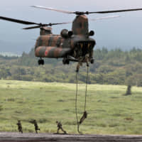 Ground Self-Defense Force soldiers rappel from a CH-47 Chinook helicopter during an annual training session near Mount Fuji at Higashifuji training field in Gotemba, Shizuoka Prefecture, on Aug. 22. | REUTERS