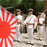 Japanese war veterans in the country\'s Imperial Navy uniform stand at attention with the navy flag as they pay their respects to the war dead at Tokyo\'s Yasukuni Shrine to commemorate the 54th anniversary of the end of World War II on Aug. 15, 1999. | AP