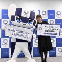 Retired wrestler Saori Yoshida poses with Miraitowa, the official mascot of the 2020 Tokyo Olympics, in Tokyo on Jan. 30 at an event promoting the sales process for tickets for the games. | KYODO