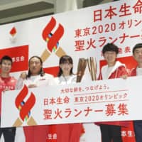 Sprinter Yoshihide Kiryu (left) and other celebrities attend an event held in Tokyo in June to announce the details for torchbearer applications for the 2020 Tokyo Olympics relay. | KYODO