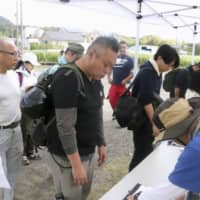 People line up to register as volunteers in Kamogawa, Chiba Prefecture, on Saturday to help residents hit by a typhoon earlier in the week. | KYODO