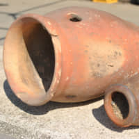 Gone to pots: Two ceramic \"tako tsubo\" pots that were used to catch octopuses now serve as nostalgic decorations at the local seafood restaurant on Shiraishi Island. | AMY CHAVEZ