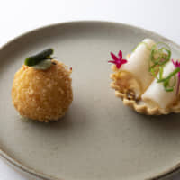 A culinary surprise : Amaebi- (sweet shrimp) filled arancini (deep-fried stuffed rice balls) crowned with blue roe (left) plated next to an abalone tartlet. | COURTESY OF COOK JAPAN PROJECT