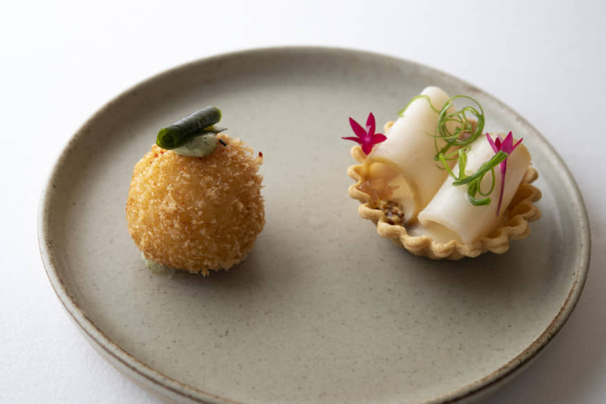 A culinary surprise : Amaebi- (sweet shrimp) filled arancini (deep-fried stuffed rice balls) crowned with blue roe (left) plated next to an abalone tartlet. | COURTESY OF COOK JAPAN PROJECT