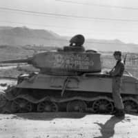 Abandoned: A soldier inspects a tank that was destroyed by U.S. forces at the battle of Taejon in 1950. | PUBLIC DOMAIN