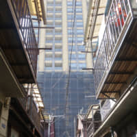 A small alley in Tsukishima, Chuo Ward, lies in the shadow of a so-called tower mansion. | ALEX MARTIN