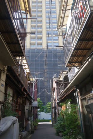 A small alley in Tsukishima, Chuo Ward, lies in the shadow of a so-called tower mansion. | ALEX MARTIN