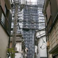 Power lines clutter the skyline in an alley in Tsukishima, Chuo Ward. | ANDREW LEE