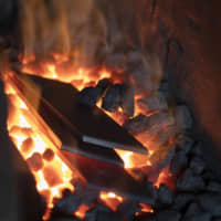 Fanning the flames: Pieces of steel are heated on charcoal in the forge. It takes keen perception to know when the steel has reached the ideal temperature. Supposedly when it takes on the color of sunset it has reached 850 degrees Celsius, but this is virtually impossible to recognize without a highly trained eye. | REUTERS