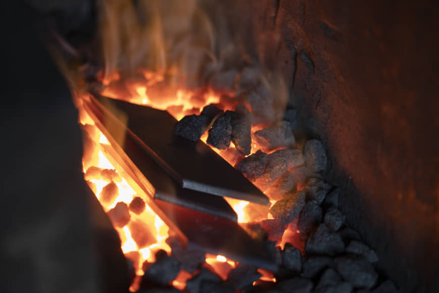 Fanning the flames: Pieces of steel are heated on charcoal in the forge. It takes keen perception to know when the steel has reached the ideal temperature. Supposedly when it takes on the color of sunset it has reached 850 degrees Celsius, but this is virtually impossible to recognize without a highly trained eye.