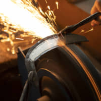 A sickle in the rough: As a sickle blade is polished, it starts out black but gradually turns a beautiful shiny silver. | REUTERS