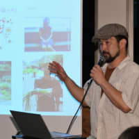 Yasu Manaka of Syoku-Yabo speaks about his efforts at the 10th Satoyama Cafe on July 16 in Tokyo. | YOSHIAKI MIURA