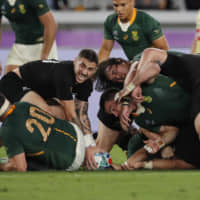 New Zealand\'s TJ Perenara (left) controls the ball after a tackle on Saturday. | AP