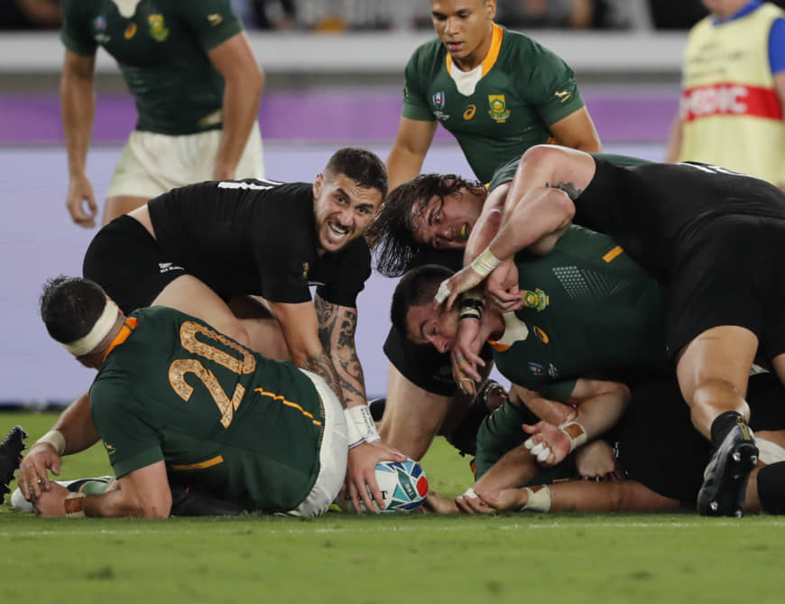 New Zealand's TJ Perenara (left) controls the ball after a tackle on Saturday. | AP