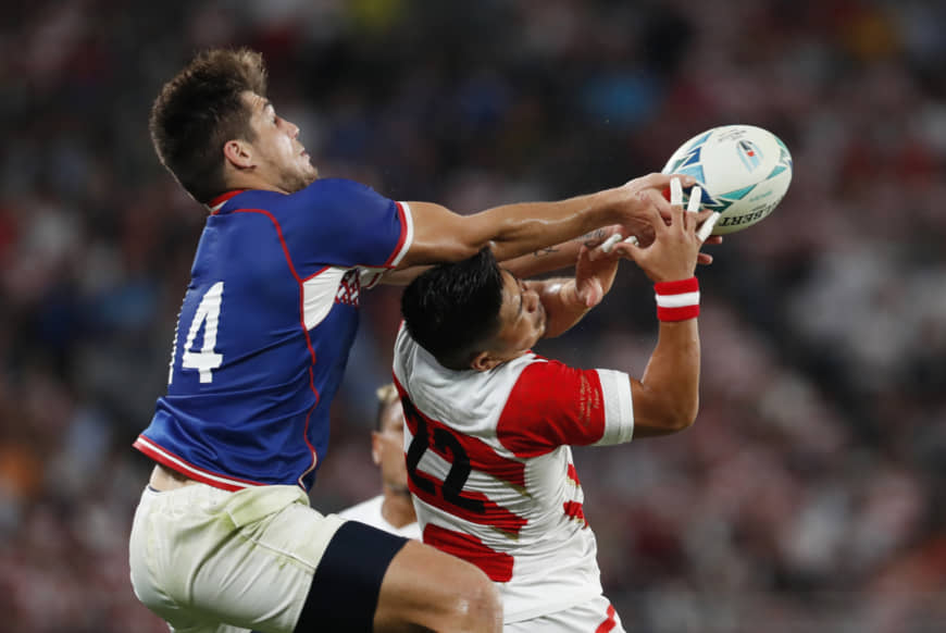 Japan's Rikiya Matsuda (right) and Russia's German Davydov battle for the ball on Friday. | REUTERS