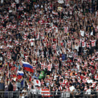 Spectators do the wave during Friday\'s Pool A game at Tokyo Stadium. | AP