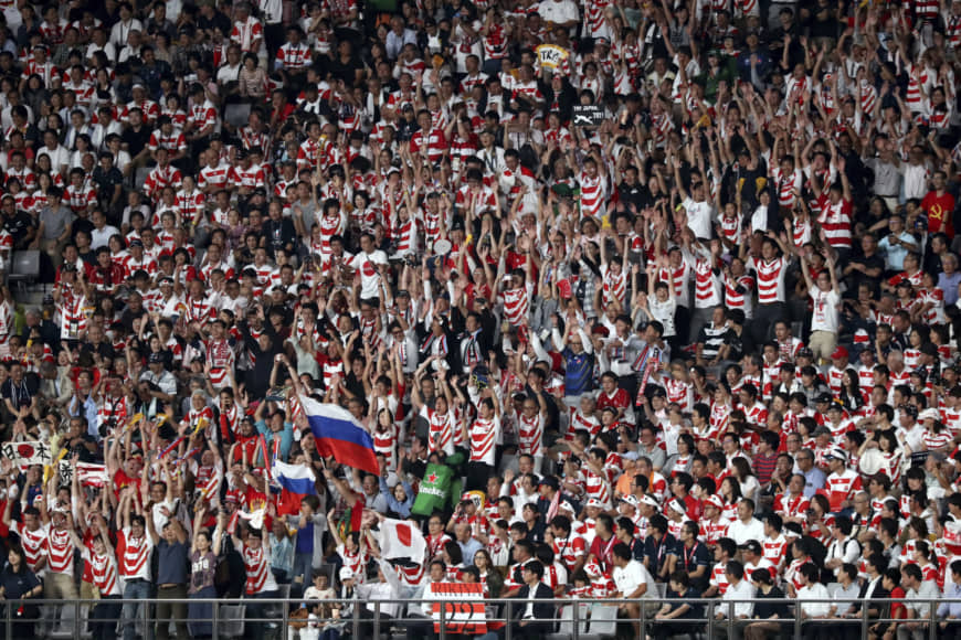 Spectators do the wave during Friday's Pool A game at Tokyo Stadium. | AP
