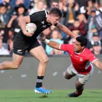Tonga\'s Malietoa Hingano (right) tries to tackle New Zealand\'s George Bridge in a test match on Saturday in Hamilton, New Zealand. | AFP-JIJI