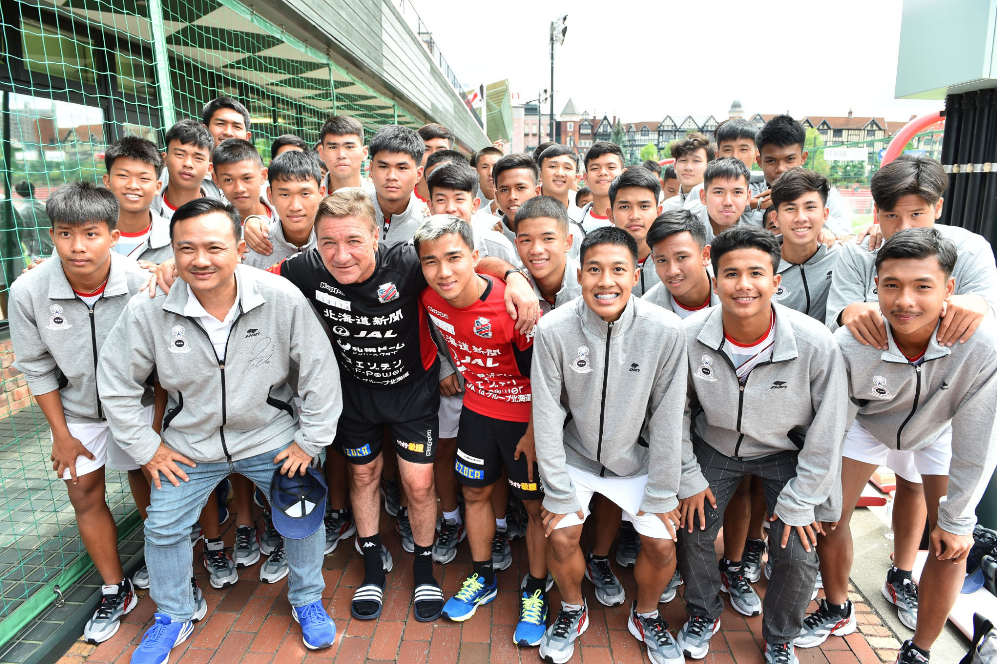Consadole Sapporo manager Mihailo Petrovic and midfielder Chanathip Songkrasin pose with visiting Thai players in August at the team's training ground in Sapporo. | COURTESY OF J. LEAGUE