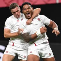 England center Manu Tuilagi (right) celebrates with fly-half teammate George Ford after scoring a try against Tonga in Sapporo on Sunday night. | AFP-JIJI
