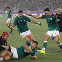 Ireland\'s Andrew Conway (bottom center) scores a try during his team\'s Rugby World Cup pool stage win over Scotland on Sunday at International Stadium Yokohama. | AP