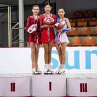 Bronze medalist Rino Matsuike (right) shares the podium with winner Lee Hae-in of South Korea (center) and second-place finisher Daria Usacheva of Russia at the Junior Grand Prix in Riga on Saturday night. | INTERNATIONAL SKATING UNION