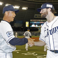 Lions pitcher Zach Neal shakes hands with manager Hatsuhiko Tsuji after their win over the Buffaloes on Wednesday in Tokorozawa, Saitama Prefecture. | KYODO