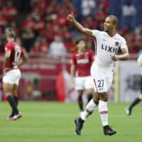 Kashima defender Bueno gives a thumbs up sign after scoring the opening goal against Urawa during the first leg of their Levain Cup quarterfinal on Wednesday in Saitama. | KYODO