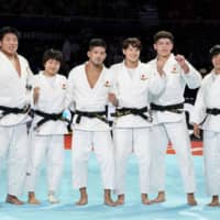 Japan\'s judoka celebrate winning their third straight mixed-team gold medal at the world judo championships on Sunday at Nippon Budokan. | KYODO