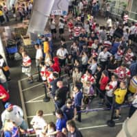 Rugby fans wait in line for concessions on Friday during halftime of the Japan-Russia game at Tokyo Stadium. World Rugby announced on Monday that it will allow fans to carry their own food into venues after a series of complaints about long queues and sold-out stands. | KYODO