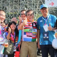 Former Japan national team forward Yoshihiko Sakuraba (second from right)and fans pose for a photo at Kamaishi Unosumai Recovery Memorial Stadium before Wednesday\'s Uruguay-Fiji game. | KAZ NAGATSUKA