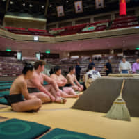 Banzuke-gai (outside the ranking sheet) returnee Urutora (foreground) sits with new recruits prior to a maezumo (pre-sumo) event on May 12, 2015. | JOHN GUNNING