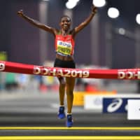 Kenya\'s Ruth Chepngetich crosses the line to win the women\'s marathon at the world championships in Doha early Saturday morning. | REUTERS