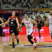 Turkey\'s Cedi Osman (center) dribbles the ball against Japan\'s Nick Fazekas (second from left) on Sunday in Shanghai. | AFP-JIJI