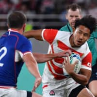 Japan\'s Ryohei Yamanaka carries the ball past Russia\'s Ramil Gaisin in a Rugby World Cup Pool A match on Friday at Tokyo Stadium. | AFP-JIJI