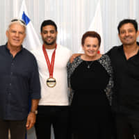 Sagi Muki (second from left), gold medalist in the World Judo Championships Tokyo 2019 men\'s 81-kilogram weight class, poses with (from left) Moshe Ponte, president of the Israel Judo Association, Israeli Ambassador Yaffa Ben-Ari and Israel\'s national coach, Oren Smadja, during a party to celebrate Israel\'s first World Judo Championship men\'s gold medal at the ambassador\'s residence on Aug. 30. | YOSHIAKI MIURA