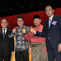 Malaysian Ambassador Dato\' Kennedy Jawan (second from right) poses with (from left) Mikio Sasaki, president of the Japan-Malaysia Economic Association; Malaysian Deputy Minister of Defense Liew Chin Tong; and Keiji Furuya, Diet member and chairman of both the Japan-Malaysia Parliamentary Friendship Association and Japan-Malaysia Association, during a reception to celebrate Malaysia\'s national day at the Imperial Hotel Tokyo on Sept. 16. | YOSHIAKI MIURA