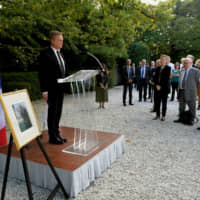 French Ambassador to Japan Laurent Pic (left) and some 200 people offer a silent prayer at the ambassador\'s residence in Tokyo on Monday in memory of former French President Jacques Chirac, who died Thursday. | YOSHIAKI MIURA