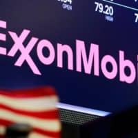 The logo for ExxonMobil appears above a trading post on the floor of the New York Stock Exchange last year. New York\'s attorney general is accusing Exxon Mobil of lying to investors about how profitable the company will remain as governments impose stricter regulations to combat global warming. The lawsuit is set to go to trial Tuesday. | AP