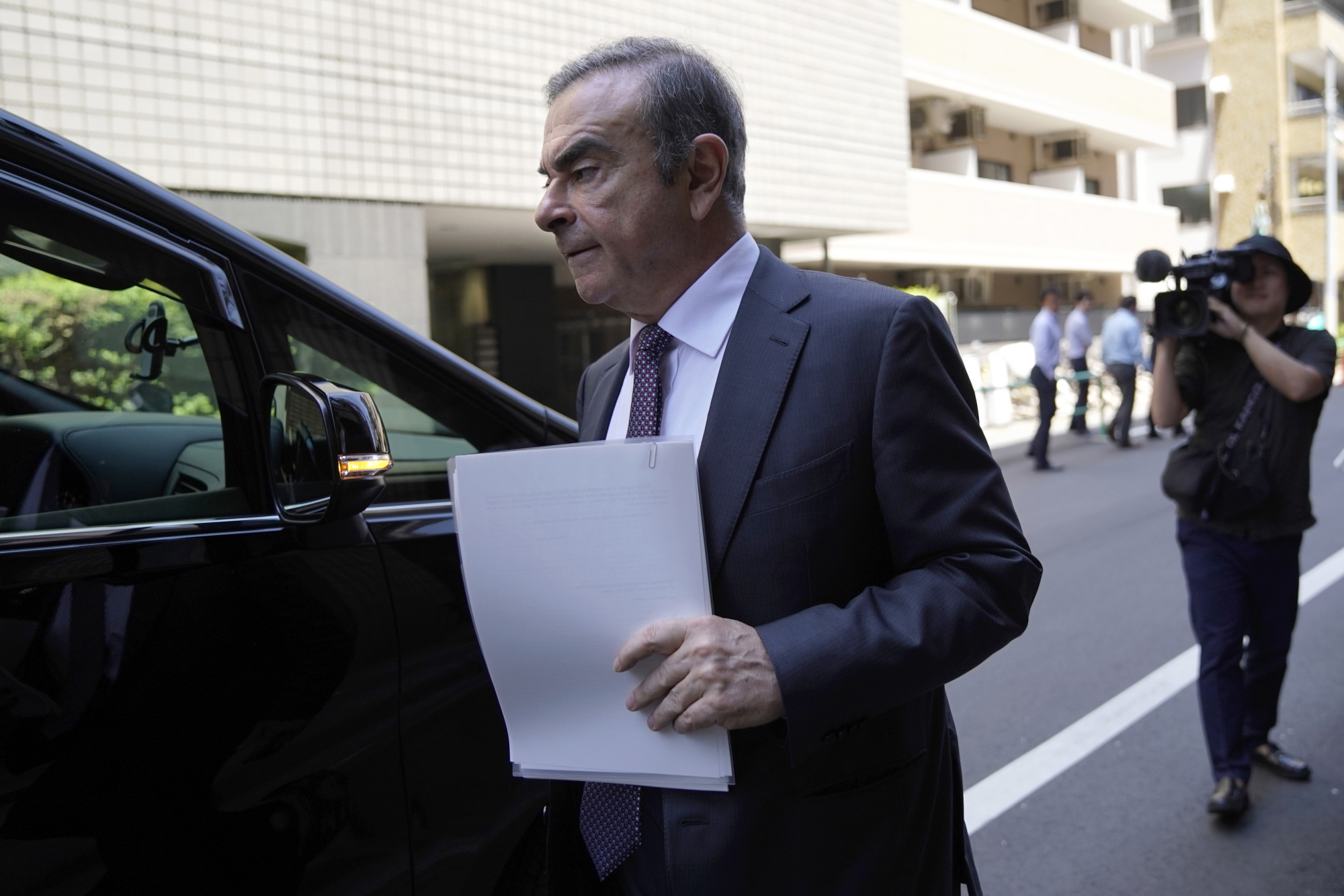 Carlos Ghosn, former chairman of Nissan Motor Co., walks toward a vehicle as he leaves his lawyer's office in Tokyo in May. | BLOOMBERG