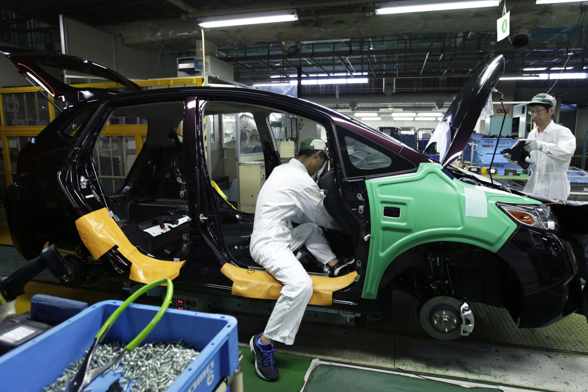 Workers assemble Honda Motor Co. North America-bound Fit vehicles on the production line of the company's factory in Suzuka, Mie Prefecture, in 2016. | BLOOMBERG