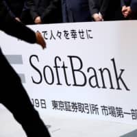 A SoftBank Corp. placard is prepared during a ceremony to mark the company\'s debut on the Tokyo Stock Exchange in Tokyo last December. | REUTERS