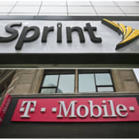 This  2018 photo combo shows signage for a Sprint store in New York\'s Herald Square and signage at a T-Mobile store in New York. T-Mobile says it expects its combination with Sprint to close next year as it awaits a December antitrust trial with a group of state attorneys general. | AP