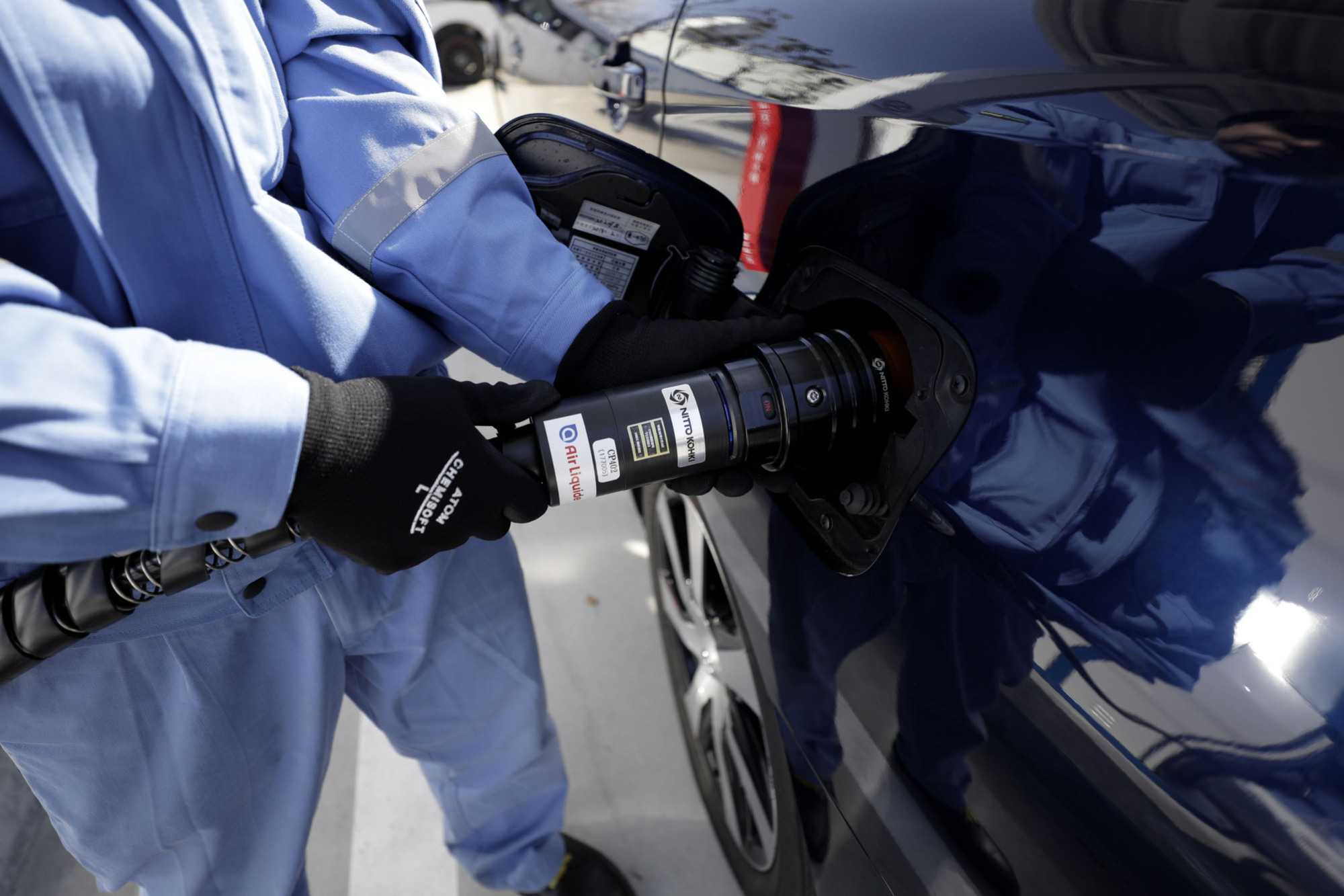 An employee refuels a Toyota Motor Corp. first-generation Mirai fuel cell vehicle during a demonstration at a hydrogen station in Kawasaki in March 2018. | BLOOMBERG