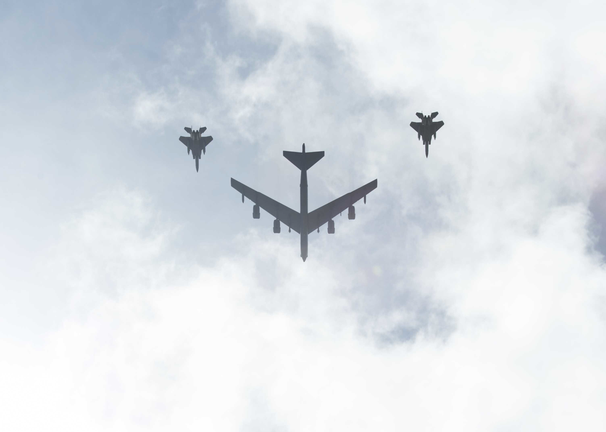 A B-52 bomber, escorted by F-15E Strike Eagle tactical ground attack aircraft, flies over the 75th Guam Liberation Day parade on July 21 in Hagatna, Guam. | U.S. NAVY