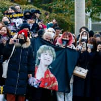 Fans of G-Dragon wait outside an army base in Yongin on Saturday. | REUTERS