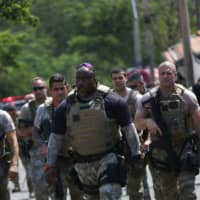 Federal police officers are seen after an armed gang robbed a securities company at the Viracopos airport freight terminal, in Campinas near Sao Paulo Thursday. | REUTERS